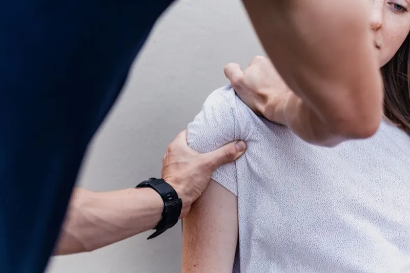 Physical therapist performing hands-on shoulder treatment