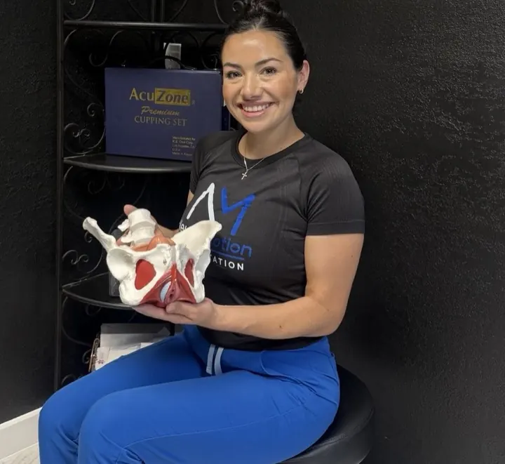 Caila Summer Padilla, occupational therapist, holding a pelvis model at NeuroMotion Rehabilitation in Weslaco
